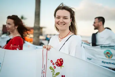 Participants hold the rushnyk in the evening wind